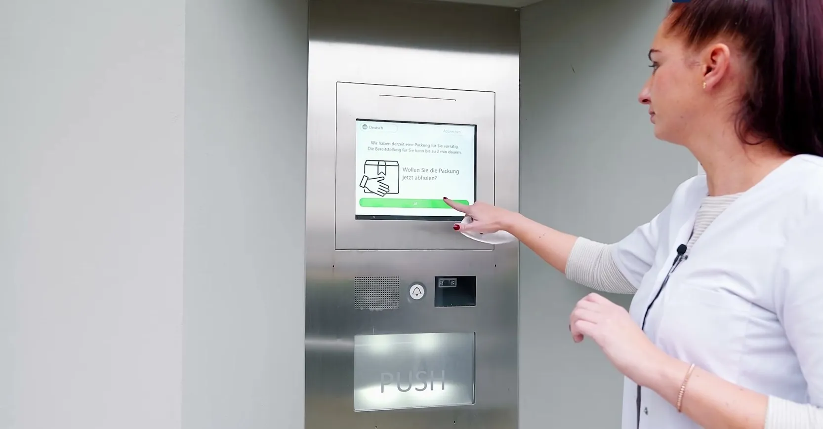 Kundin bedient das Terminal des Abholautomaten