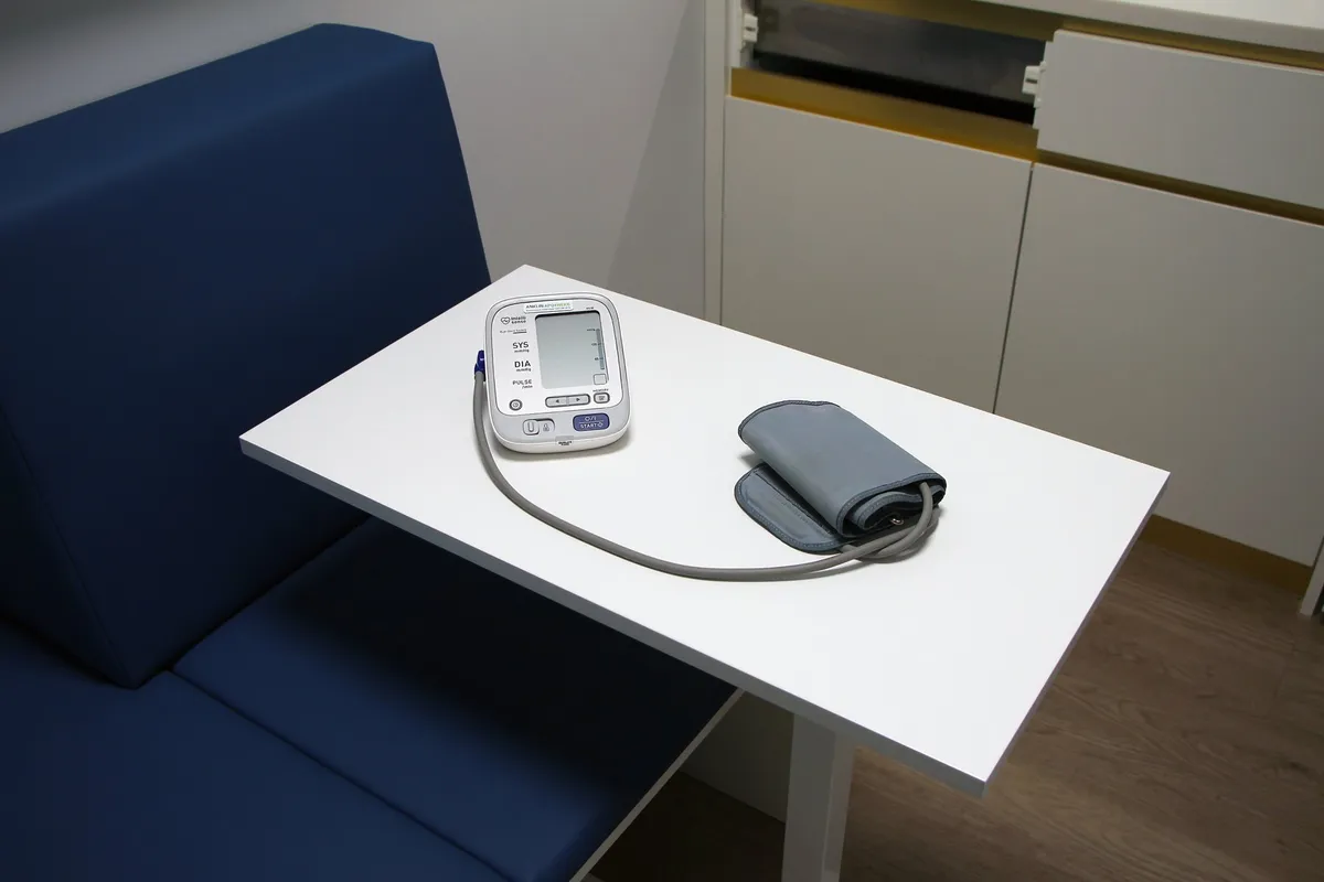Oberarm-Blutdruckmessgerät mit Manschette auf einem Tisch im Beratungsraum