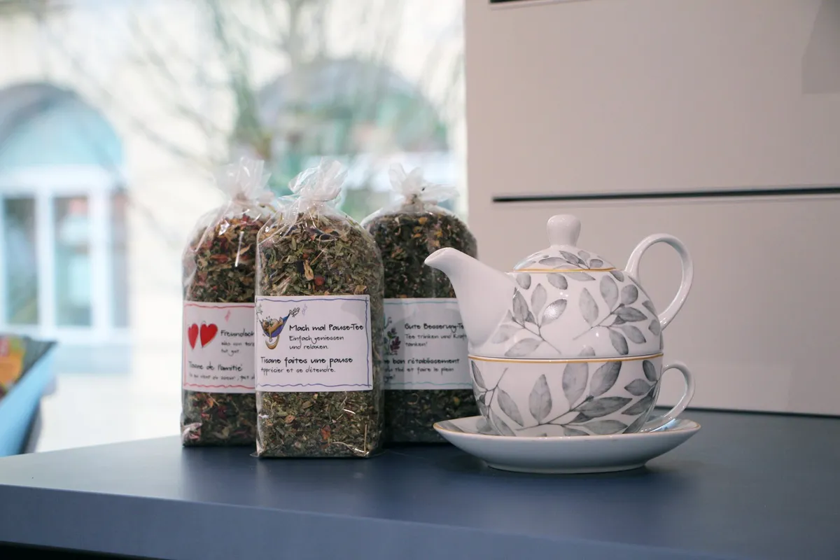 Kräutertee-Beutel und Teekanne auf dem Fenstertisch der Apotheke