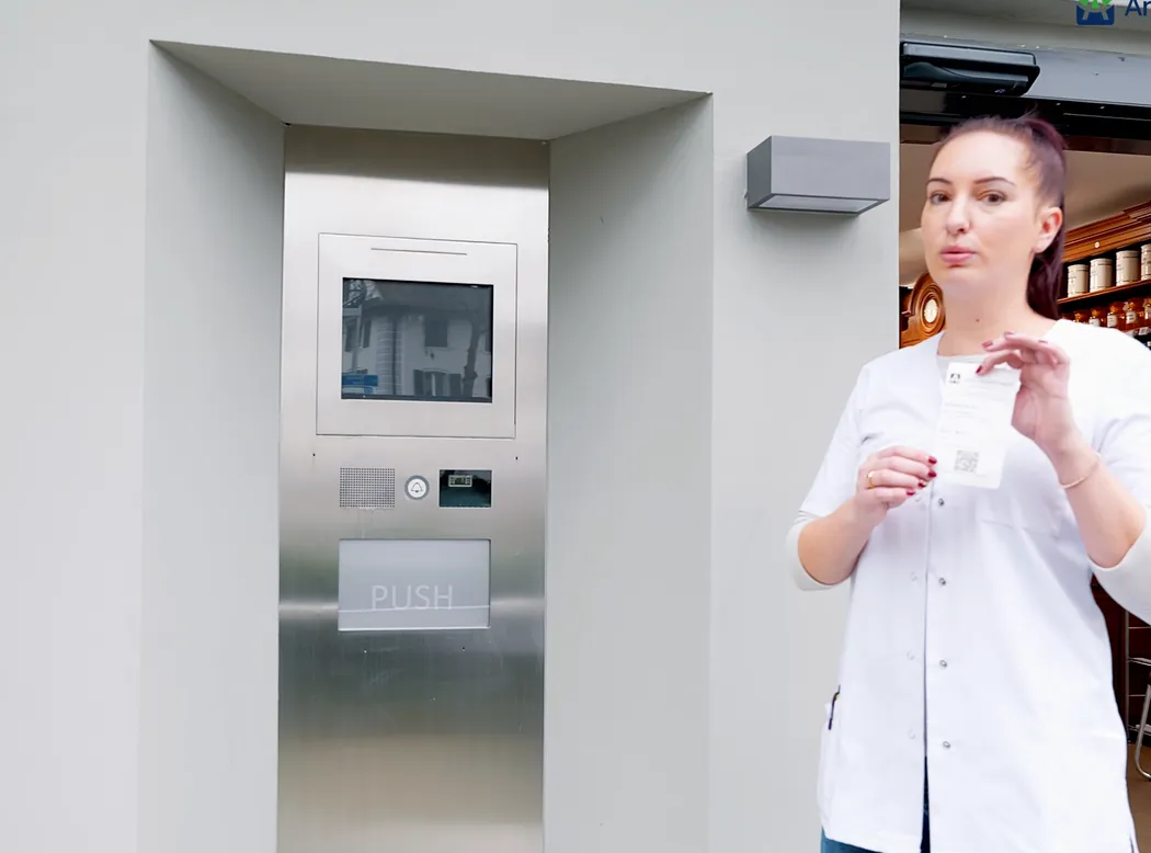Kundin bedient das Terminal des Abholautomaten